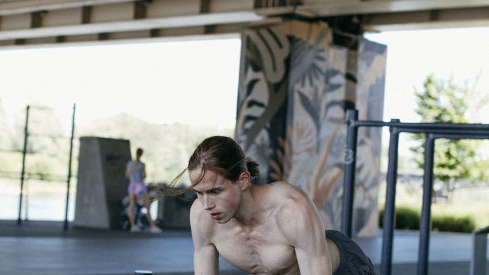 Man performing a bodyweight exercise in a minimalist gym.